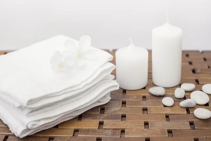 Upscale spa treatment room with folded towels and calming feminine decor, representing private intimate beauty and skincare services