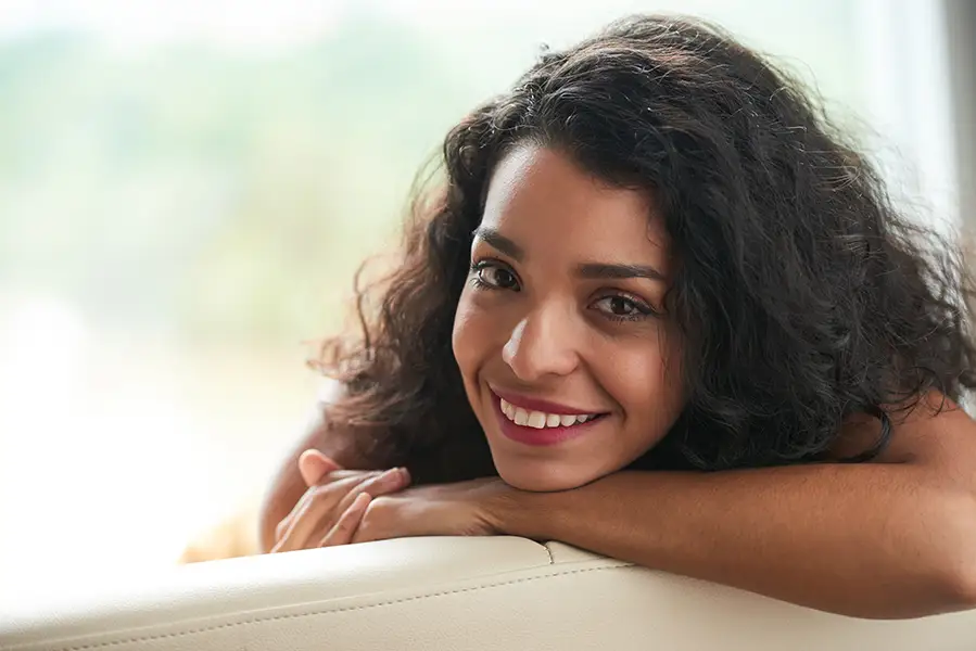 Confident adult woman with glowing skin and a relaxed smile, representing beauty, confidence, and personalized intimate brightening care