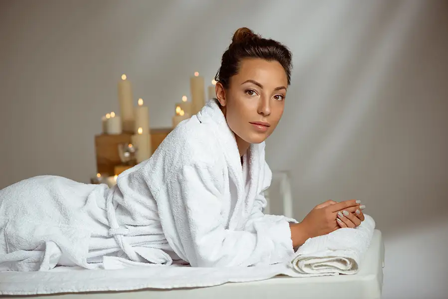 Relaxed woman in a luxury spa robe in a bright private treatment room, representing discreet intimate skincare and self-care in Los Angeles County